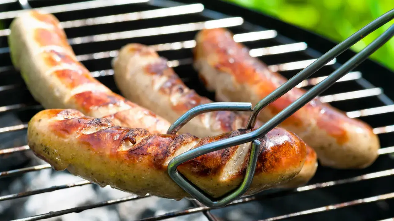 Bratwurst grillen: Saftige Würste brutzeln auf dem Rost, bereit für den Genuss.