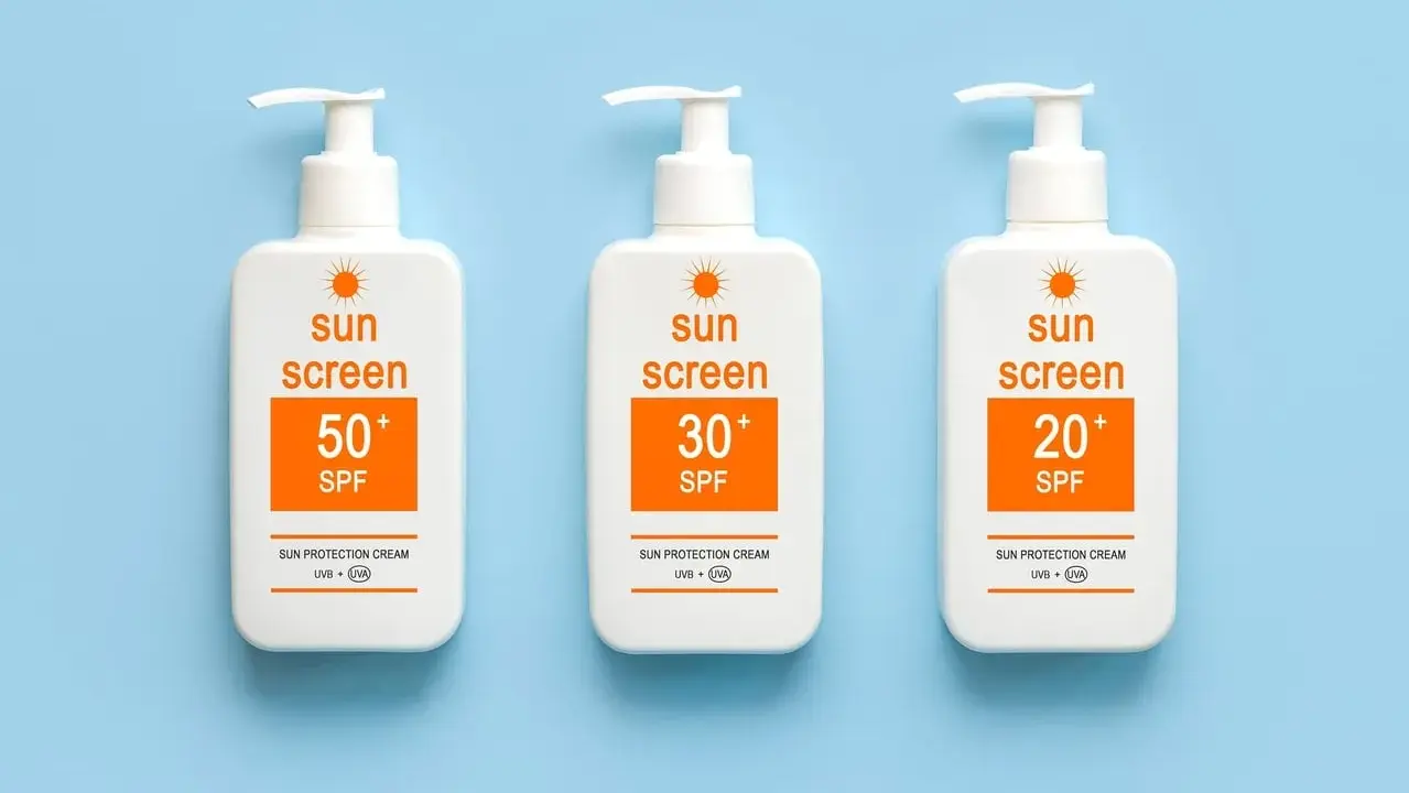 Trois bouteilles de crème solaire avec des indices SPF variés (50+, 30+, 20+). Le SPF signification est la protection contre les rayons du soleil.