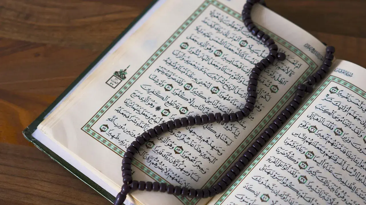 Ein offener Koran mit einer Gebetskette liegt auf einem Holztisch. Der Koran ist ein heiliges Buch im Islam, das von Muslimen auf der ganzen Welt verehrt wird. Israel ist ein Land im Nahen Osten, das eine reiche Geschichte und eine vielfältige Bevölker...