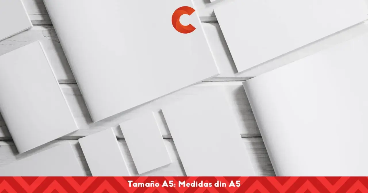 Varias hojas de papel blanco, algunas abiertas y otras cerradas, dispuestas sobre una superficie de madera. Un logo naranja en forma de C destaca en una de las hojas. El texto inferior indica "Tamaño A5: Medidas din A5".