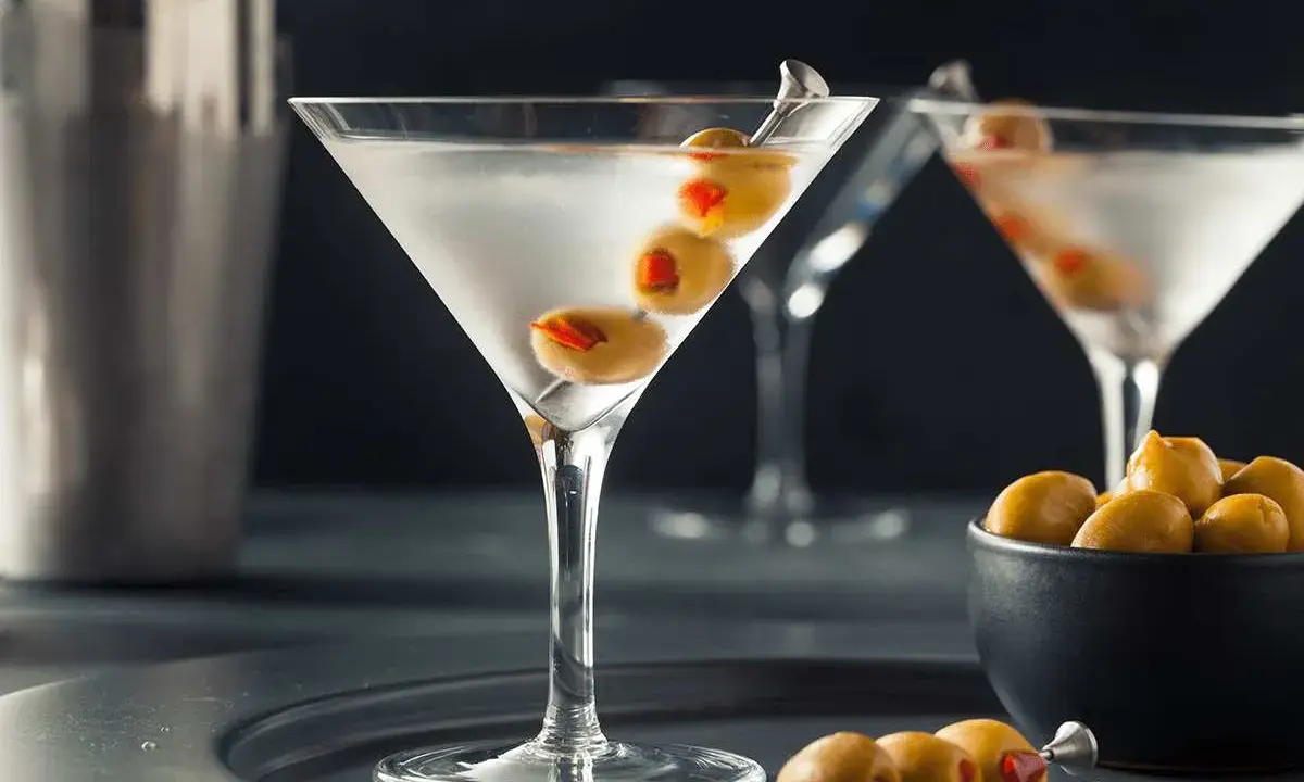 En elegant martini, en klassisk James Bond-drink, med oliver på ett cocktailspett.