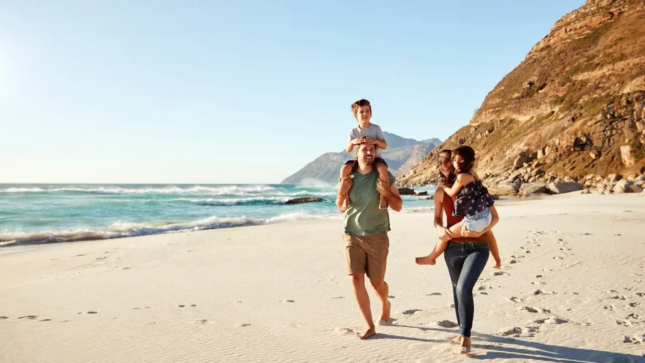 Glad familj på stranden. För att undvika att smittas av hepatit b, undvik delade personliga föremål.