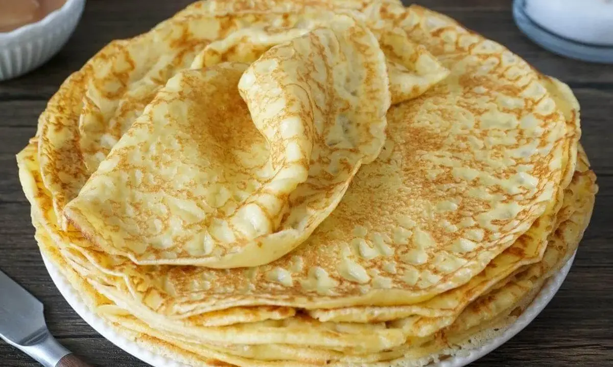 Stapel goldbrauner Pfannkuchen auf einem Teller. Perfekt zum Einfrieren für später.