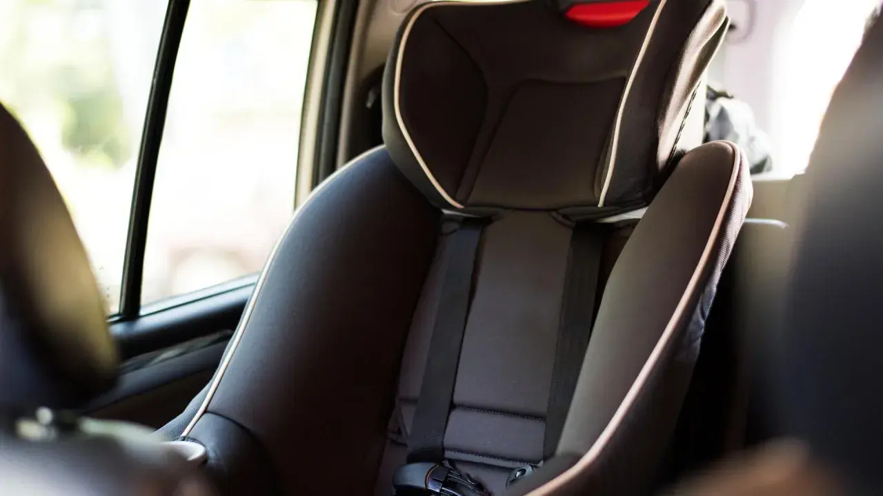 Silla de coche infantil, con cinturón de seguridad y detalles en blanco. La etiqueta indica ece r44/04 vigencia, asegurando su conformidad.