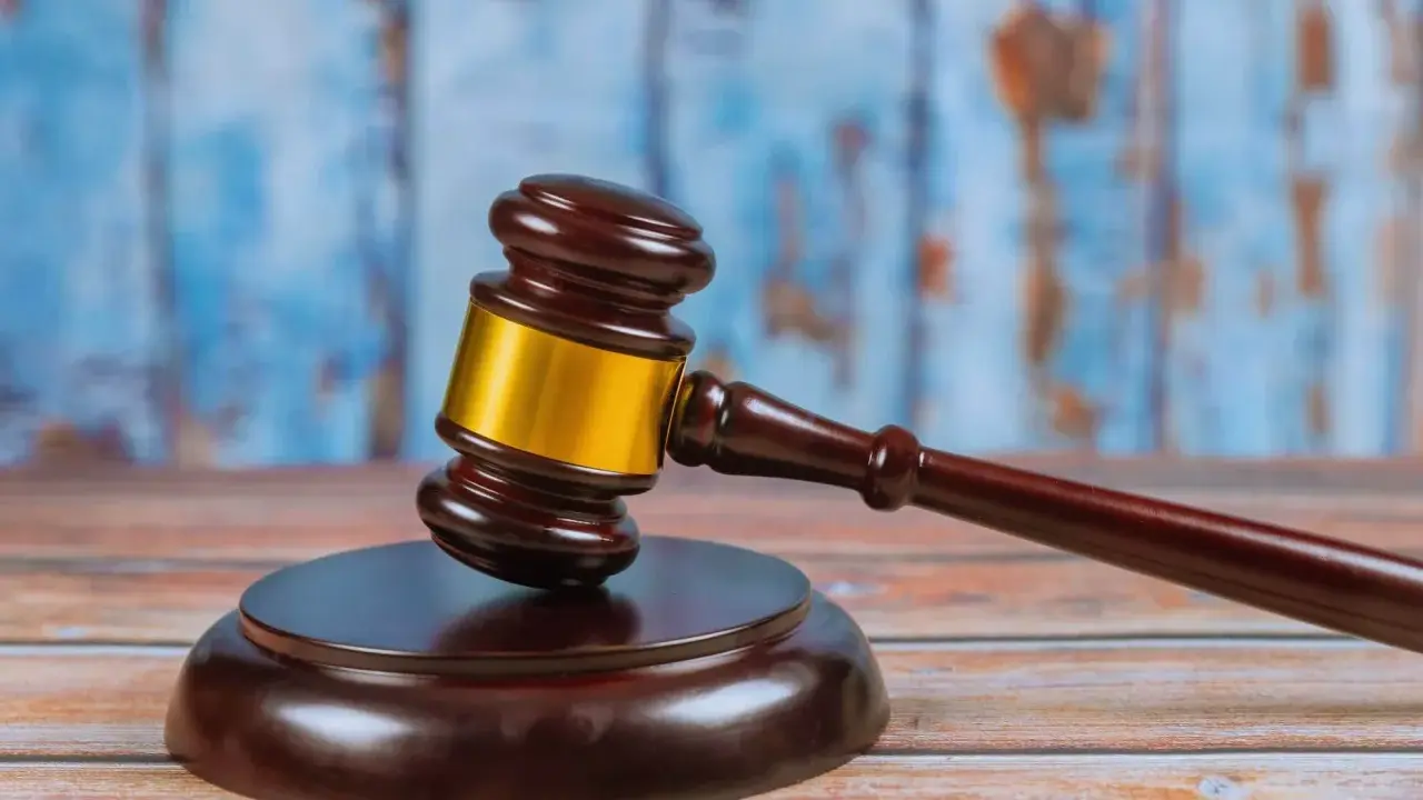 Młotek sędziowski na drewnianym stole, symbolizujący ważną decyzję prawną, jak wniosek o pozbawienie władzy rodzicielskiej.