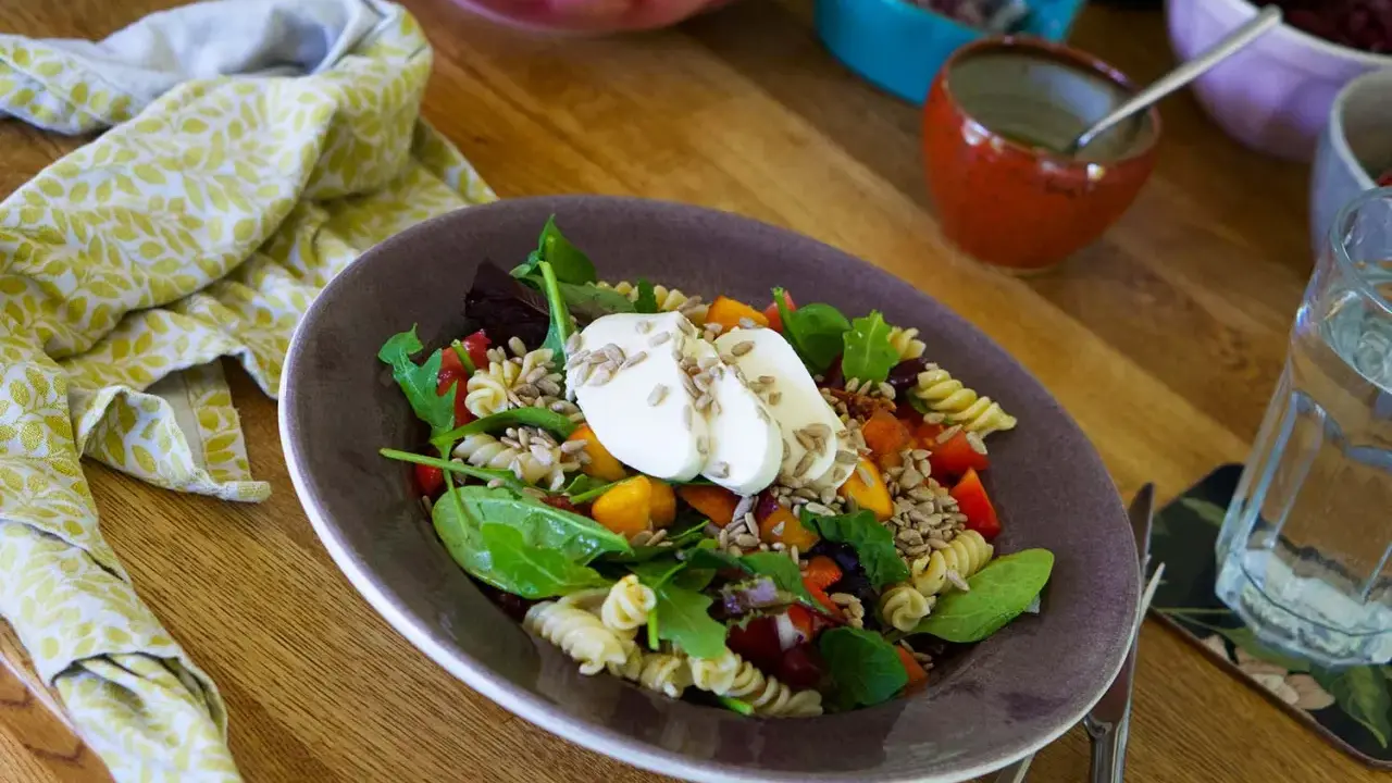 En härlig pastasallad vegetarisk med färska grönsaker, mozzarella och solrosfrön. Perfekt för en lätt lunch.