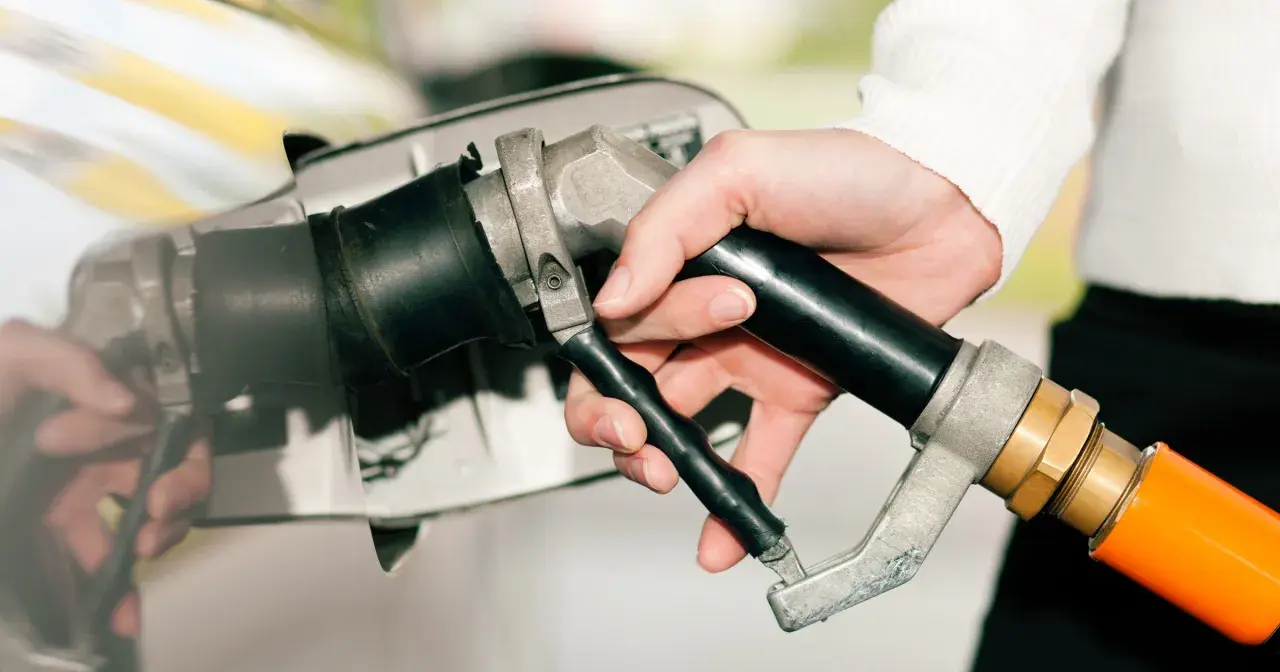 Dłoń trzymająca pistolet do tankowania, gotowa do nalania gazu do diesla.