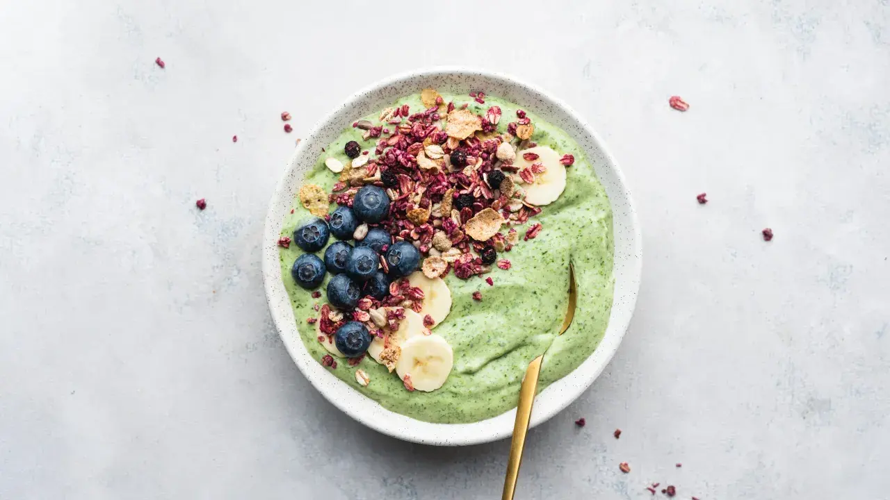 Grön smoothiebowl med blåbär, banan och granola. Perfekt för frukost tips!