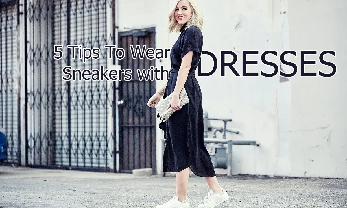 A woman shows how to wear sneakers with a dress, pairing white sneakers with a black midi dress and a clutch.