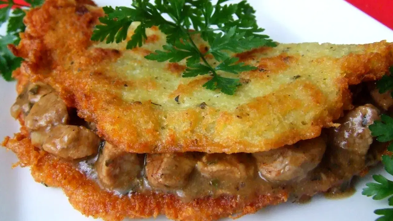 Chrupiące placki ziemniaczane z aromatycznym gulaszem mięsnym, udekorowane natką pietruszki. Pyszne danie, które zadowoli każdego smakosza.