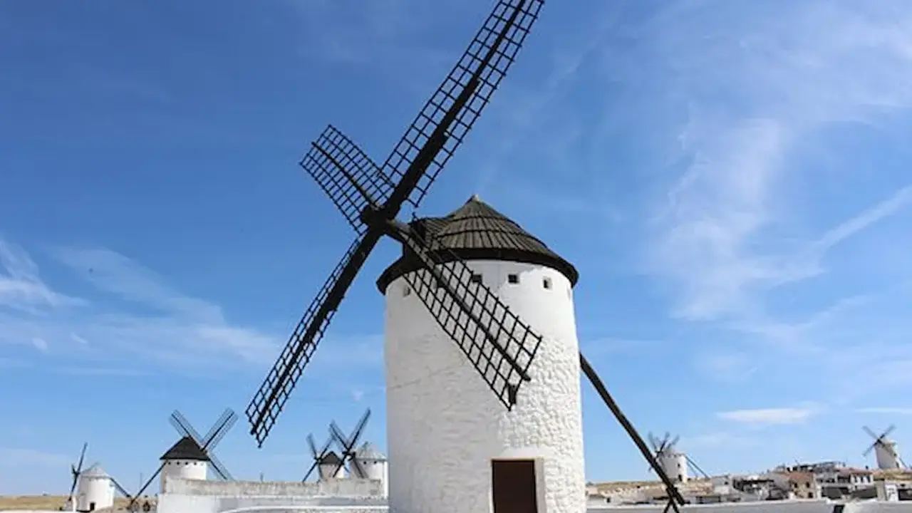 Molinos de viento blancos bajo un cielo azul. Un lugar que ver en Ciudad Real, como sacado de un cuento.