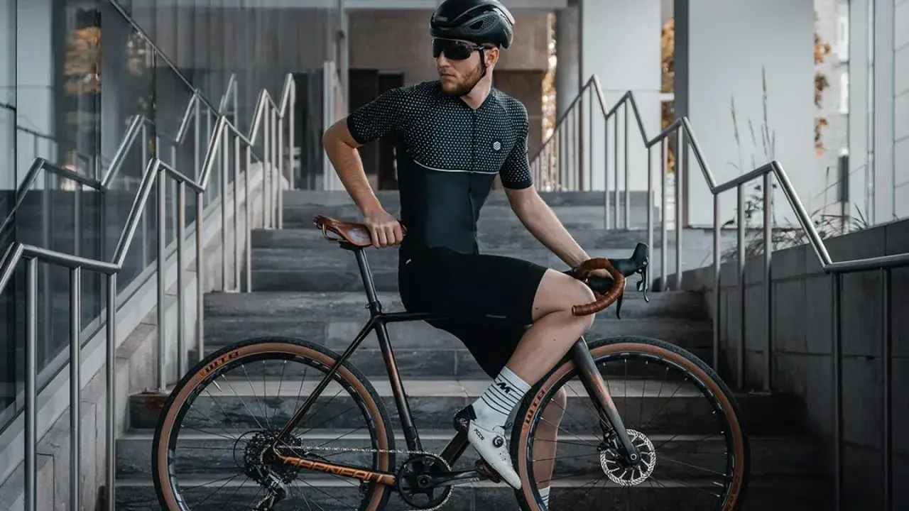 Mężczyzna w stroju kolarskim siedzi na rowerze z ramą 48 cm, idealną dla osób o wzroście ok. 170-175 cm.