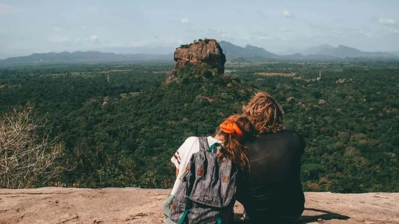 Coppia ammira Sigiriya, una delle meraviglie da vedere in Sri Lanka. Paesaggio lussureggiante e roccia imponente.