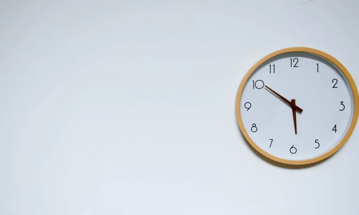 Reloj de pared blanco con marco de madera. Las manecillas marcan las 10:05, un momento clave para mi ayuno de 17 horas.
