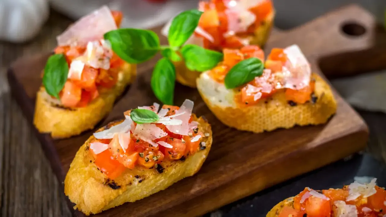 Bruschetta med färska tomater, basilika och parmesan på rostat bröd. Ett enkelt och gott bruschetta recept för alla tillfällen.