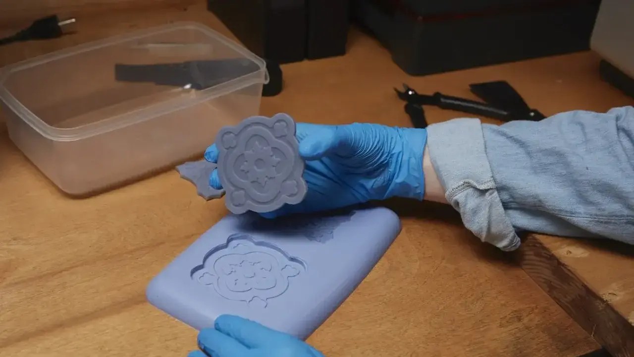 Manos enguantadas muestran un molde de silicona recién hecho, demostrando cómo hacer moldes de silicona para crear piezas decorativas.