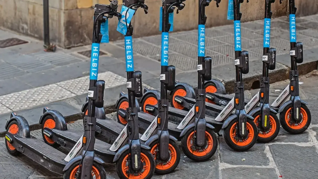 Une rangée de trottinettes électriques Helbiz, prêtes à l'emploi. Imaginez pouvoir debrider trottinette pour une balade urbaine !