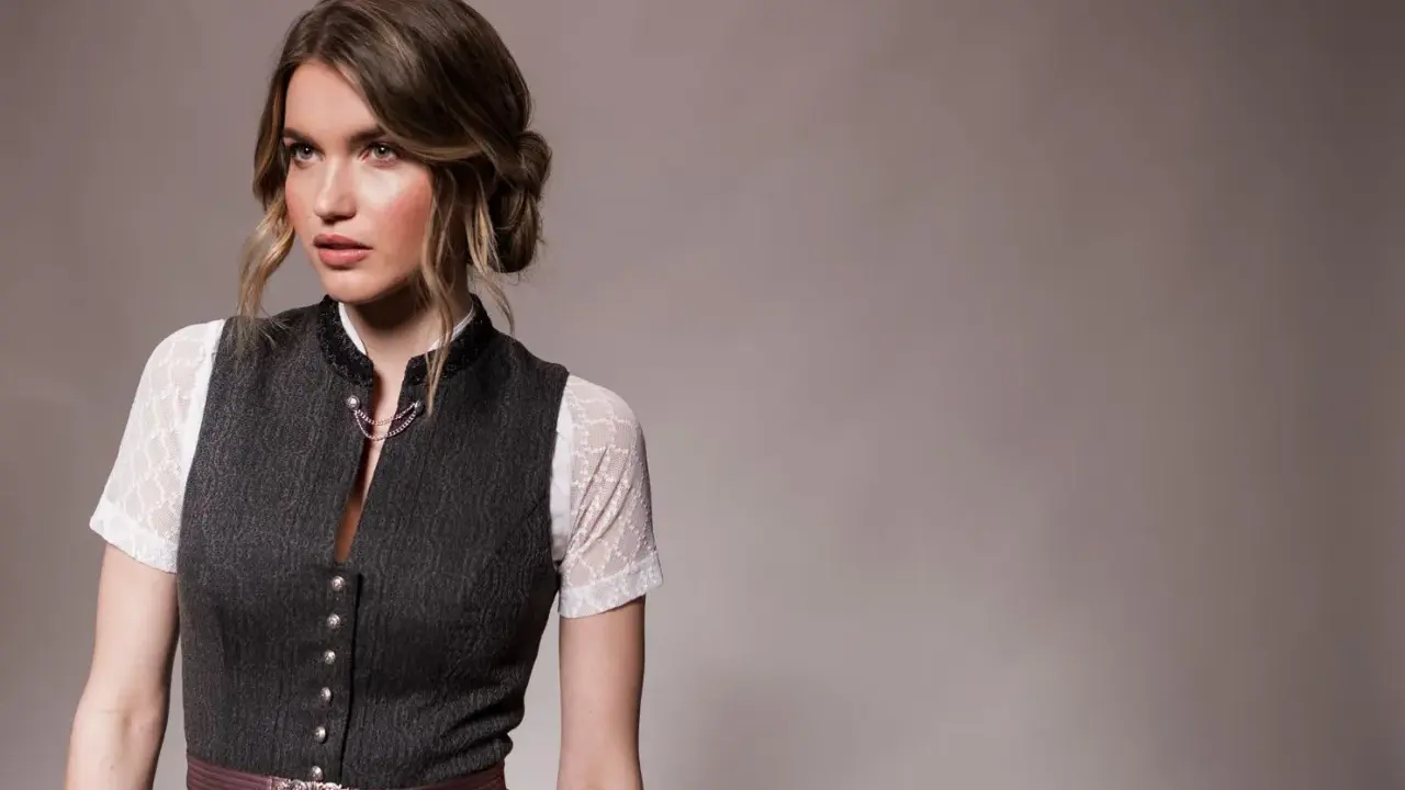 Eine Frau mit einer eleganten Dirndl-Frisur für kurze Haare trägt ein traditionelles Dirndl.