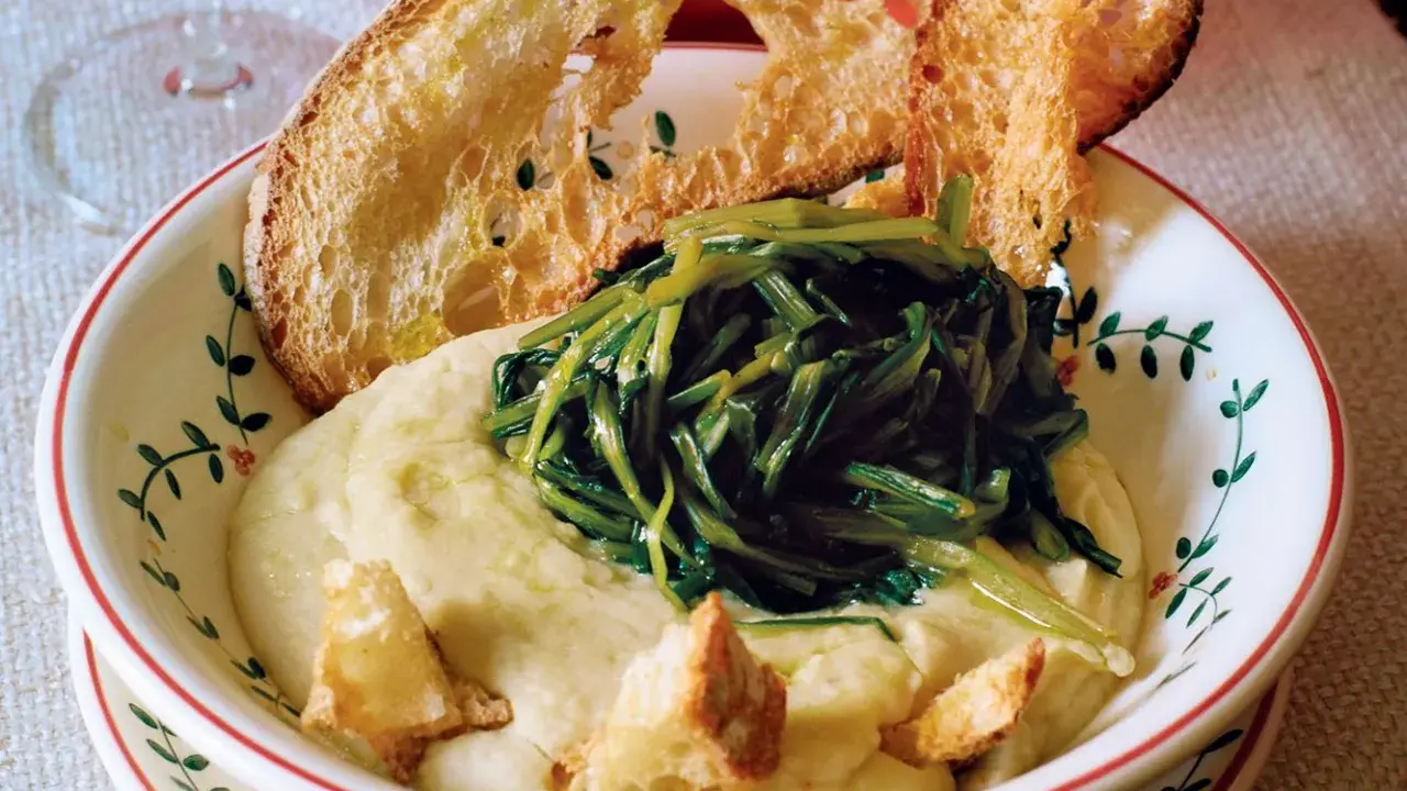 Piatto di fave e cicoria con crostini di pane abbrustolito.