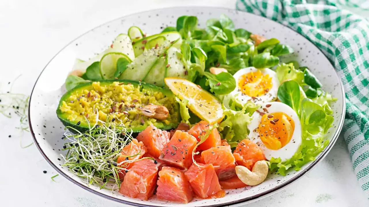 Kolorowa sałatka z łososiem, awokado, jajkiem i kiełkami – idealna na dietę niskowęglowodanową.