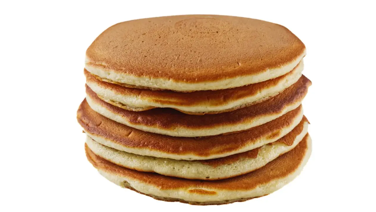 Pile de pancakes dorés faits maison avec de la farine complète, prêts à être dégustés.