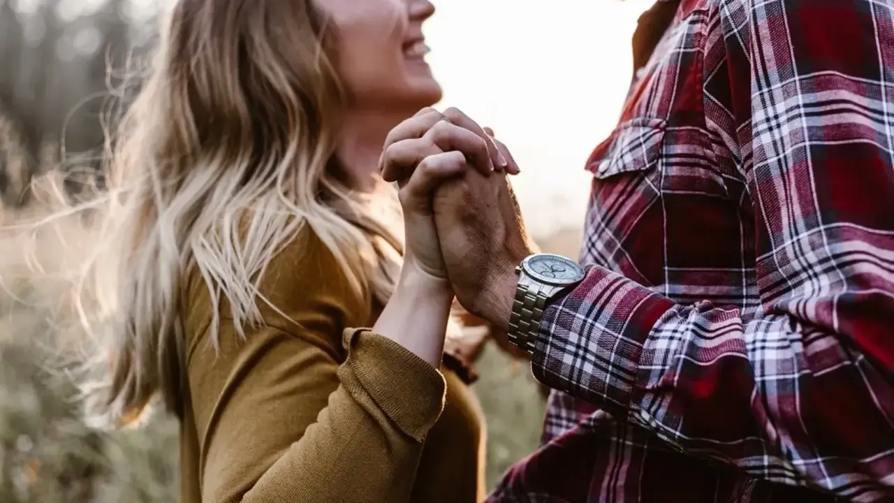Glückliches Paar hält Händchen. Sie strahlt, er trägt kariertes Hemd. Vielleicht ein Zeichen für den Vaterkomplex bei Frauen?