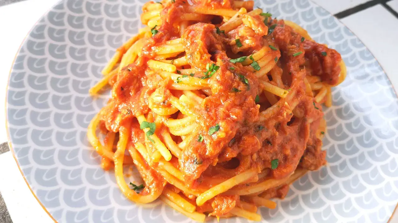 Spaghetti al tonno ricetta della nonna, un piatto gustoso e semplice, con pomodoro e tonno, guarnito con prezzemolo fresco.