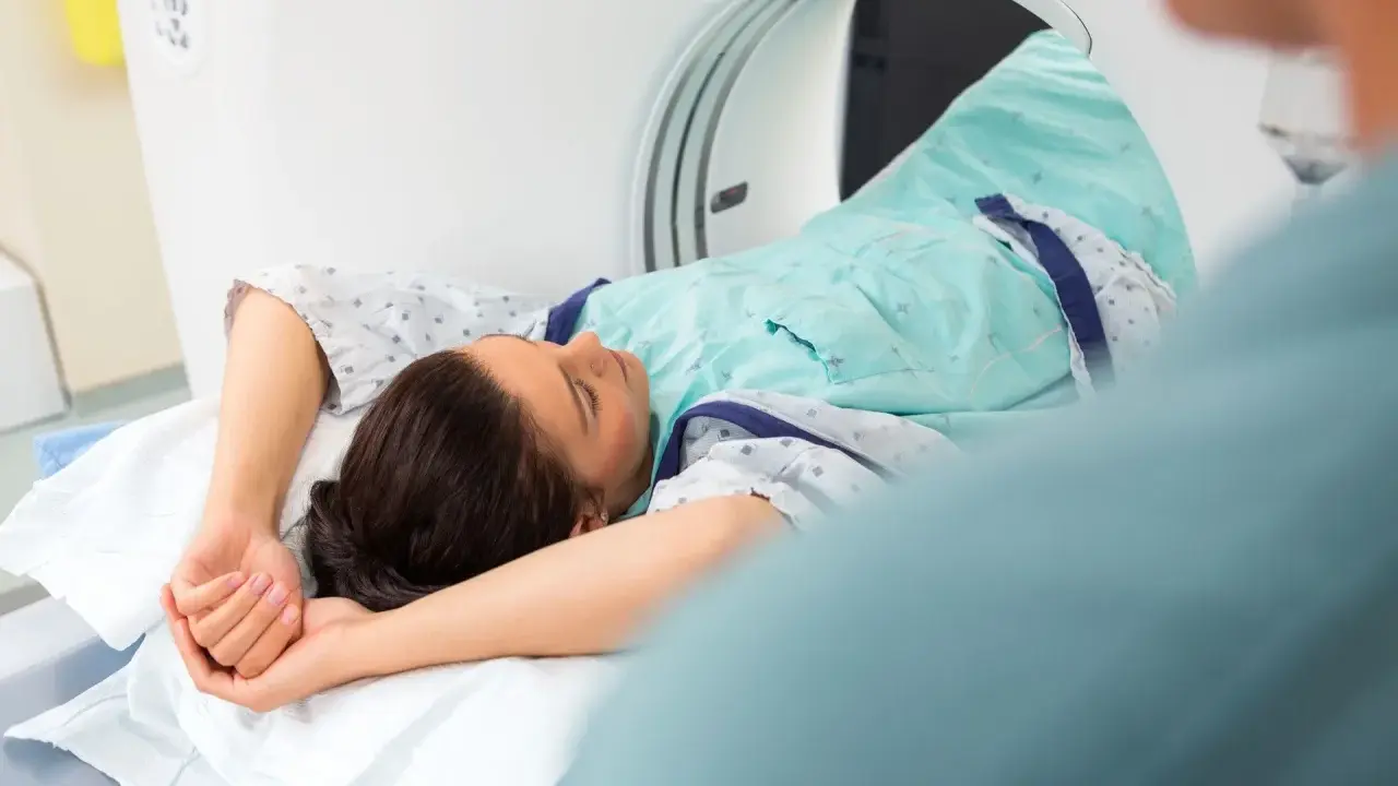Pacjentka leży w skanerze tomografii komputerowej, badanie może pomóc zdiagnozować metaplazję pęcherza moczowego objawy.