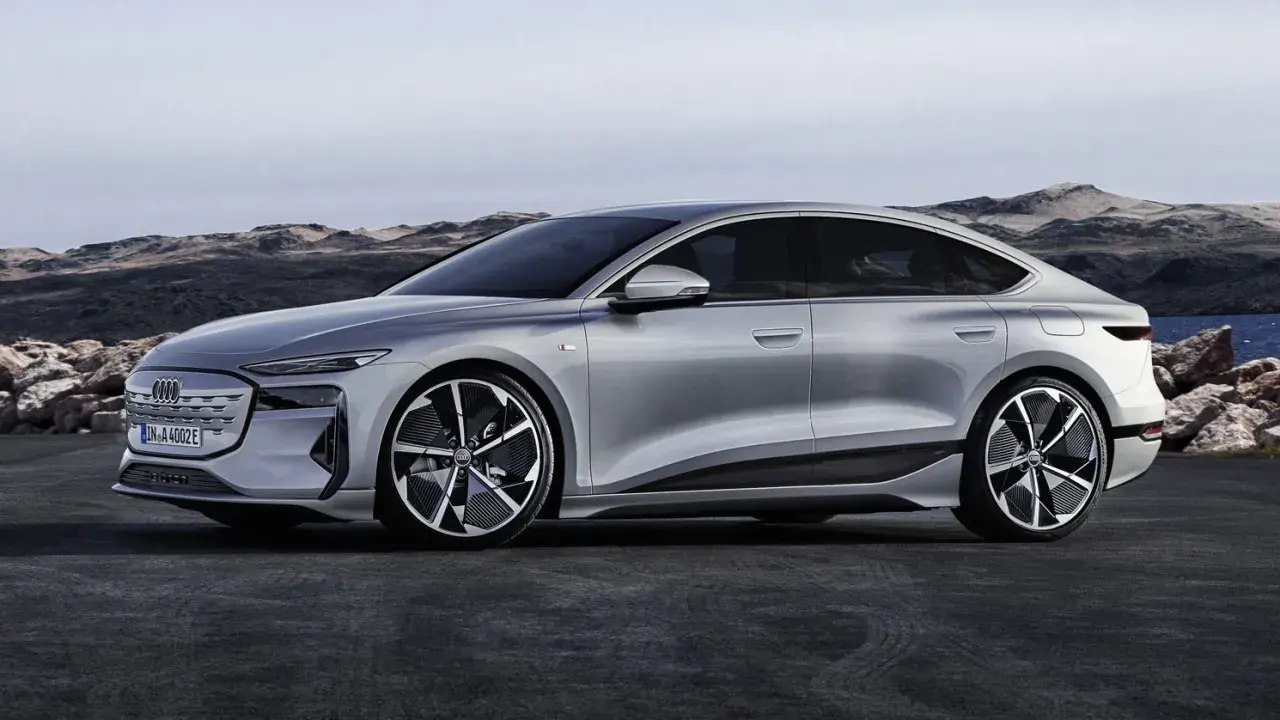 Silberner Audi A4 e-tron, ein elegantes Elektroauto, steht vor einer felsigen Küstenlandschaft.