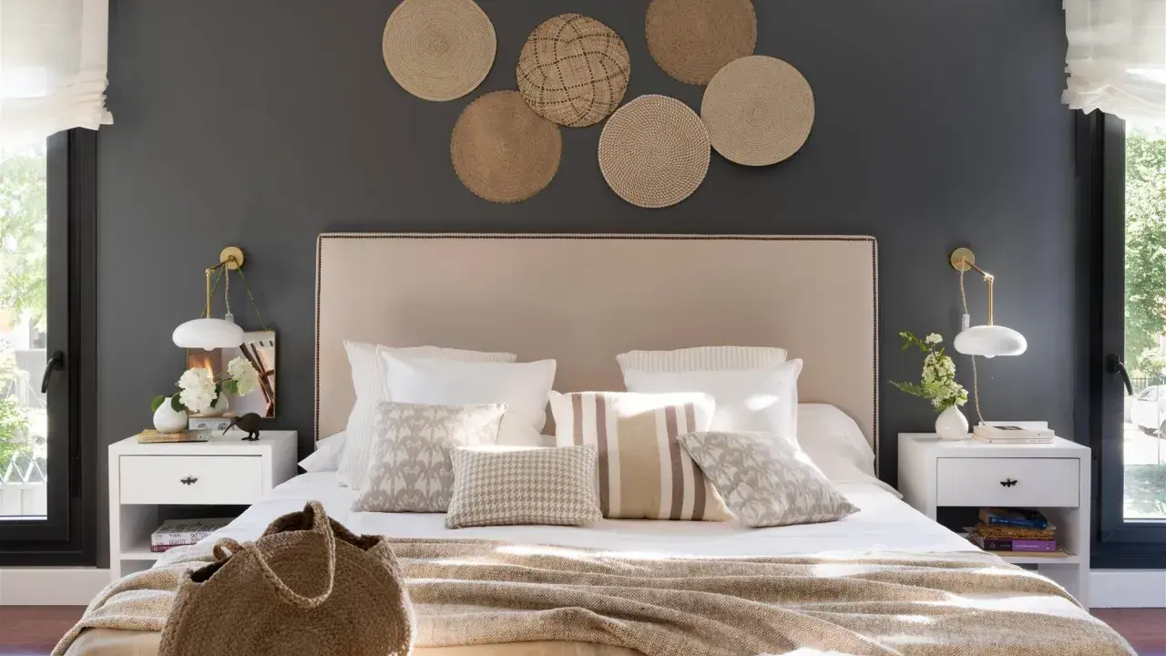 Decorar pared cabecero con fotos de mimbre crea un ambiente acogedor. Cama con cojines y manta tejida.