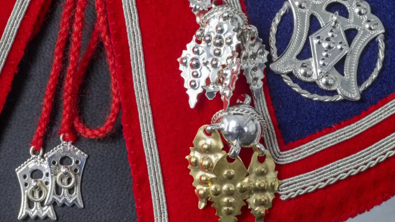 Detaljerade samiska smycken i silver och guld, som visar deras rika betydelse och hantverk.