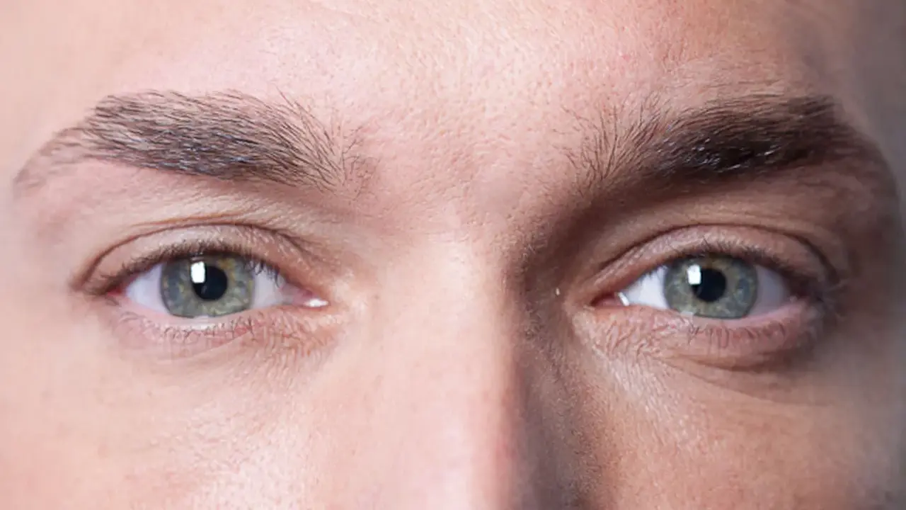 Gros plan sur les yeux d'un homme, mettant en valeur la forme naturelle de ses sourcils.