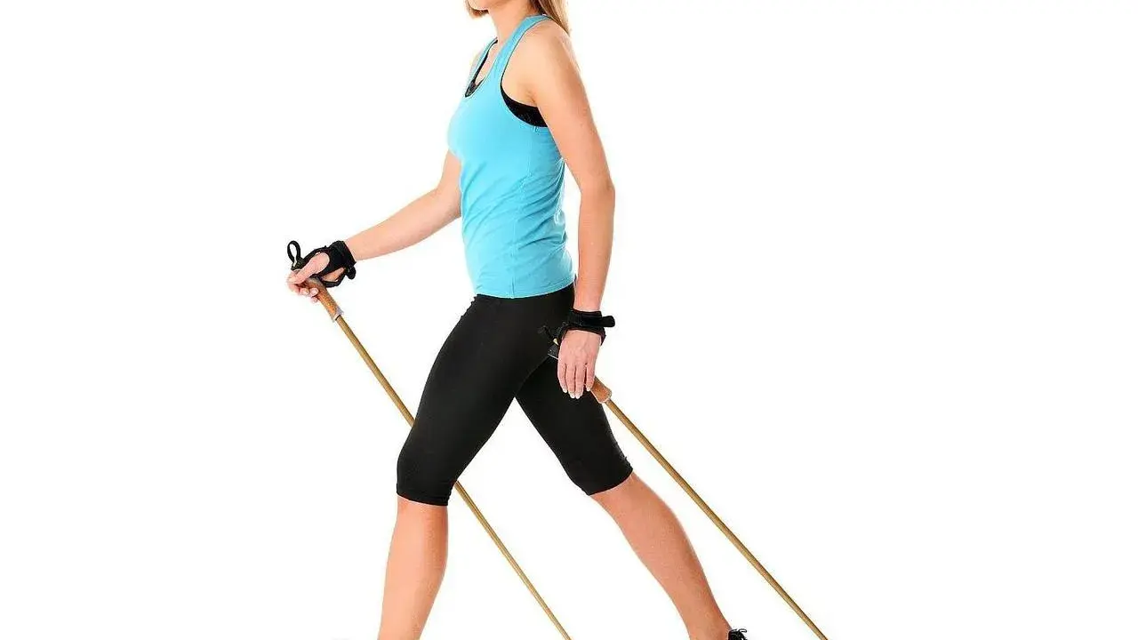 Kobieta z kijami do nordic walking. Dowiedz się, jak dobrać kije do nordic walking, by trening był efektywny i bezpieczny.