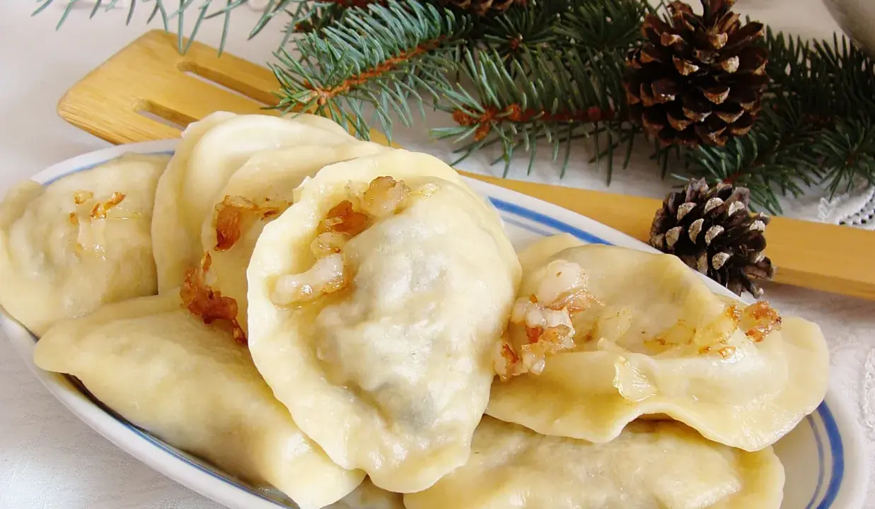 Pyszne pierogi z mięsem i kapustą, ozdobione gałązkami świerku i szyszkami, wyglądają jak świąteczny przysmak.