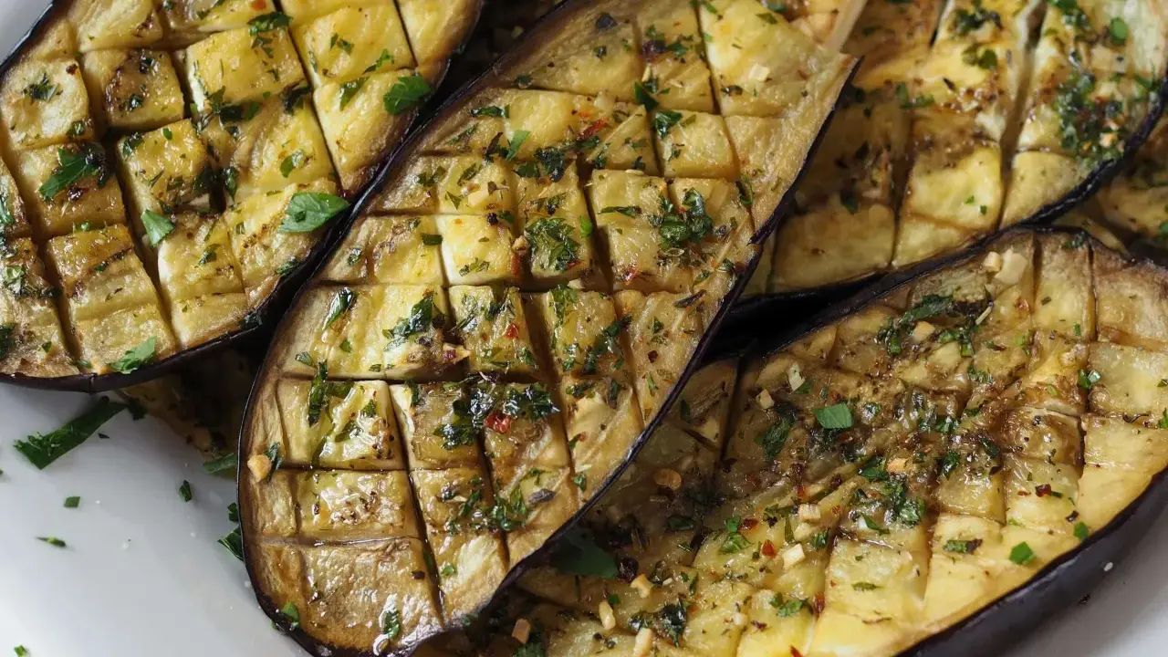 Gegrilltes Gericht mit Aubergine, gewürzt mit Kräutern und Knoblauch.