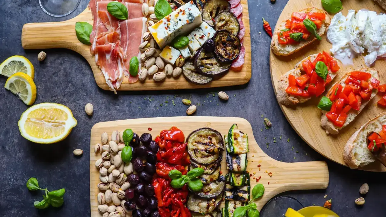 Ein köstlicher italienischer Abend mit Aufschnitt, Käse, gegrilltem Gemüse, Bruschetta und Pistazien. Perfekt für Genießer!