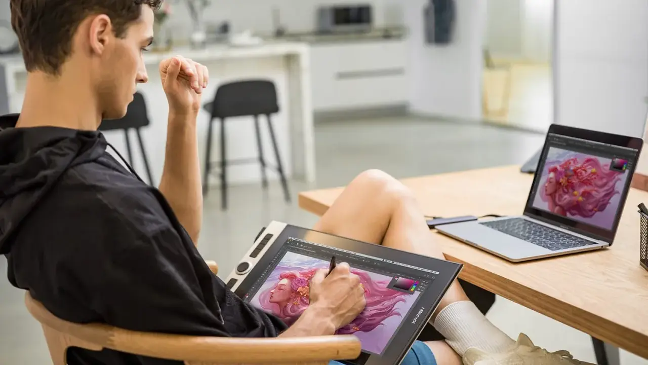 Un jeune homme utilise une tablette graphique pour créer une œuvre d'art numérique, sa configuration PC graphiste est prête pour l'inspiration.