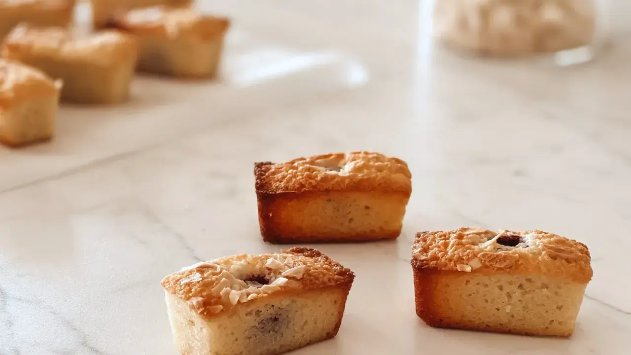Financiers dorés, parfaits pour une recette financier framboise. Ils sont garnis de fruits rouges et de flocons d'amandes.