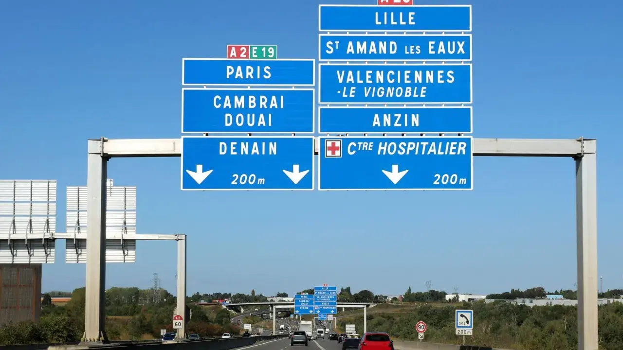 Znaki drogowe na autostradzie we Francji wskazują drogę do Lille, Paryża, Cambrai, Douai i Denain.