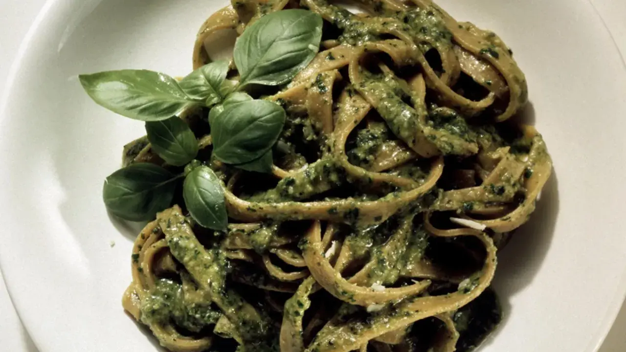 Herzhafte Bandnudeln mit cremiger Pistazien-Pesto-Sauce und frischem Basilikum garniert.