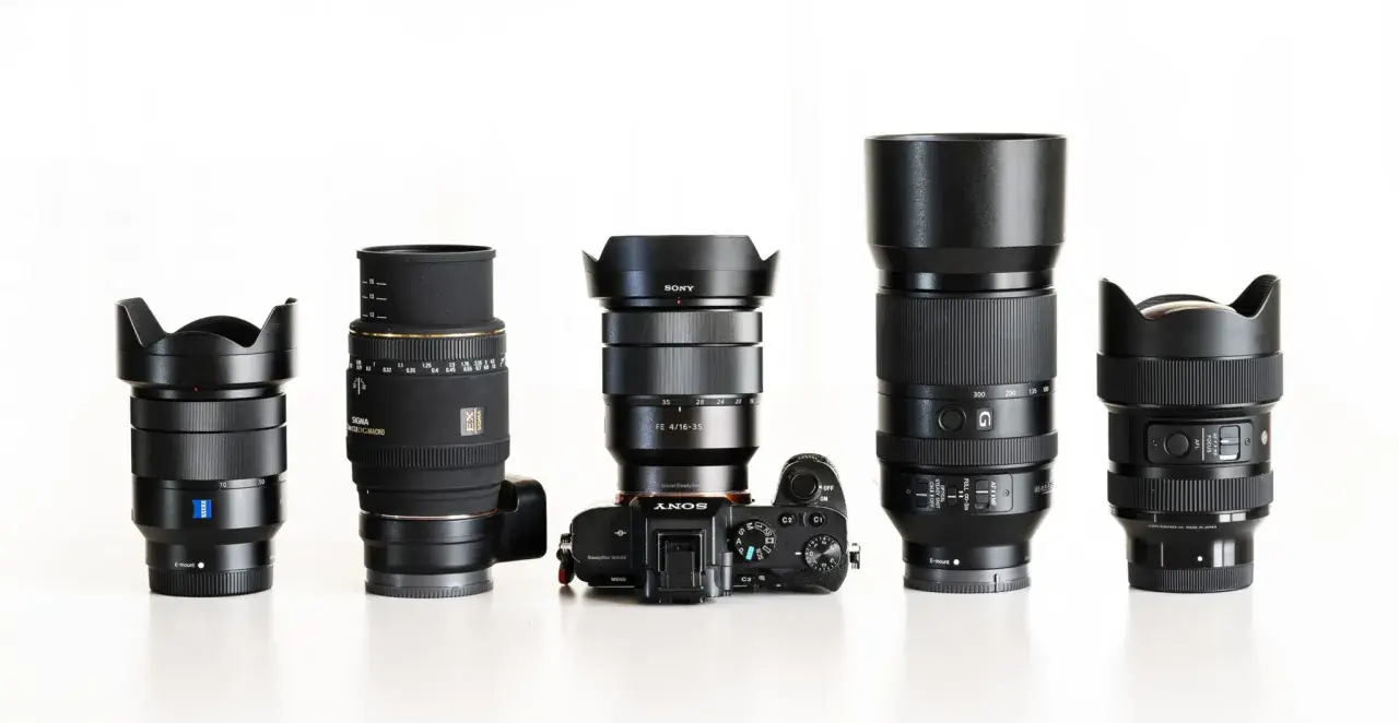 Różne obiektywy do Sony Alpha: szerokokątny Zeiss, makro Sigma, zoom Sony FE 4/16-35, teleobiektyw i jasny Sigmy.
