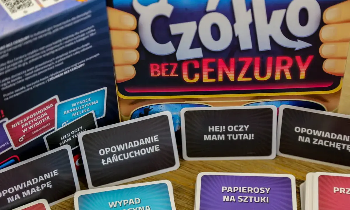 Karty do gry "Czółko bez cenzury" leżą na stole. Widać napisy: "Opowiadanie łańcuchowe", "Hej! Oczy mam tutaj!", "Opowiadanie na małpę", "Wypad do kasyna".