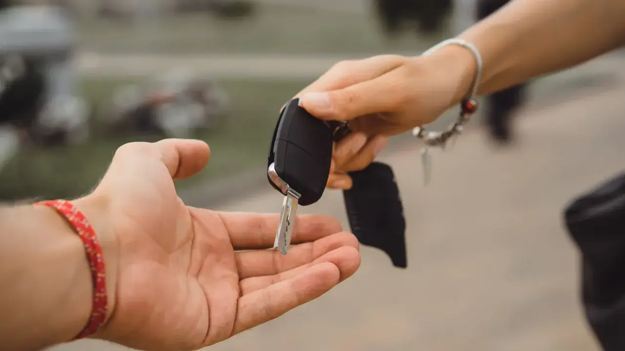 Przekazanie kluczyka samochodowego. Zastanawiasz się, ile kosztuje dorobienie klucza do samochodu z immobilizerem?