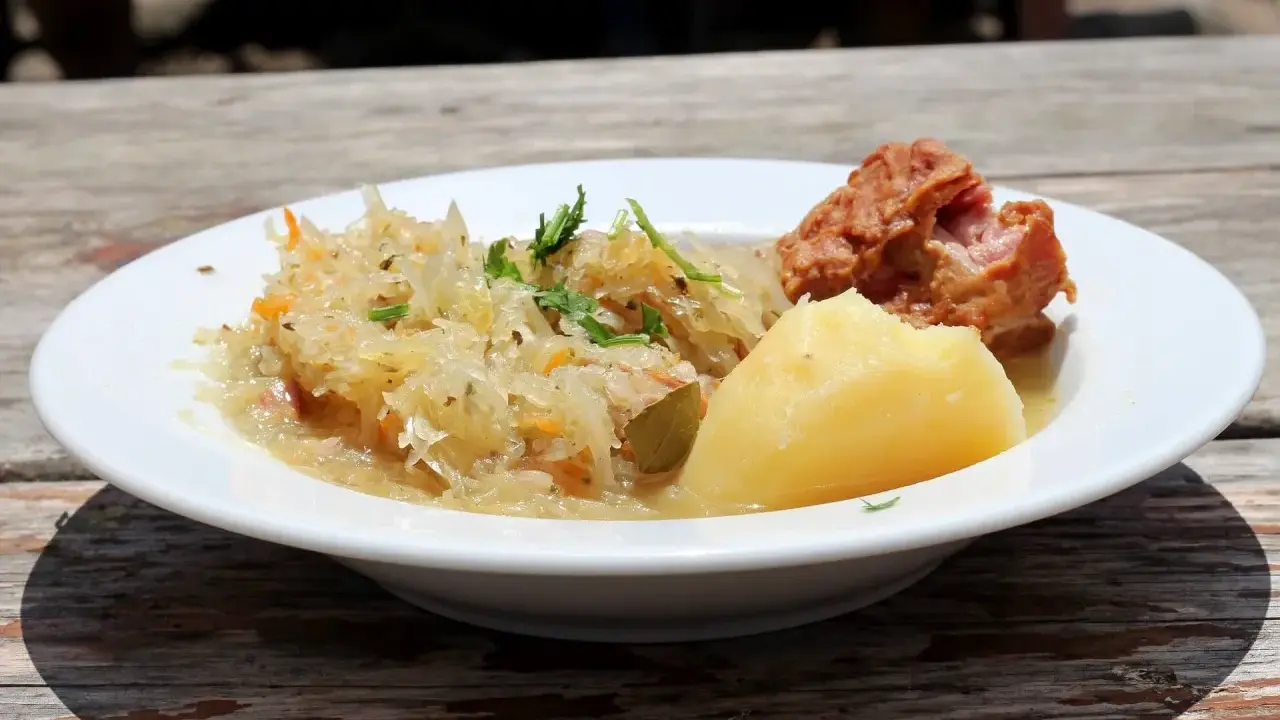 Danie z restauracji Bacówka: ziemniaki, kapusta kiszona z marchewką i kawałek mięsa. Pyszne, tradycyjne danie z menu.