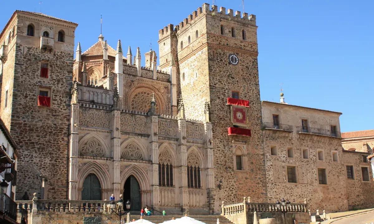 Impresionante catedral en Cáceres, con niños disfrutando de la plaza.