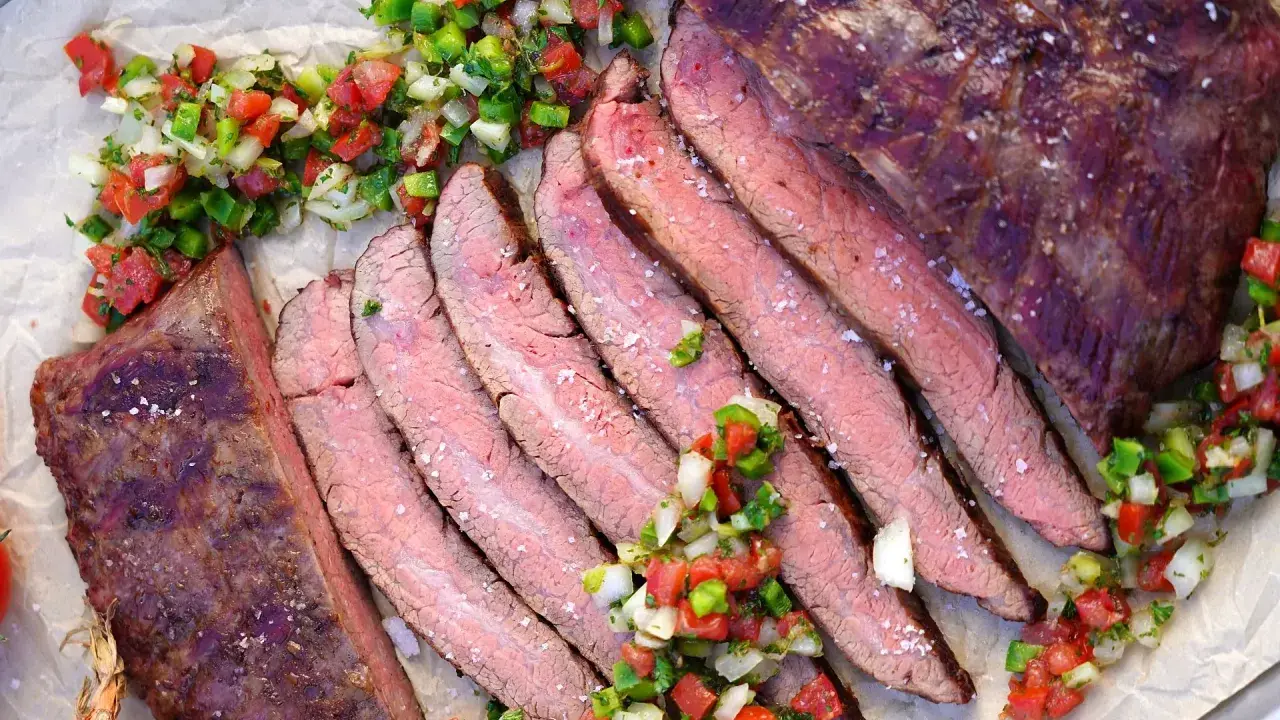 Saftiges, in Scheiben geschnittenes Flank Steak Deutsch, garniert mit frischer Salsa.
