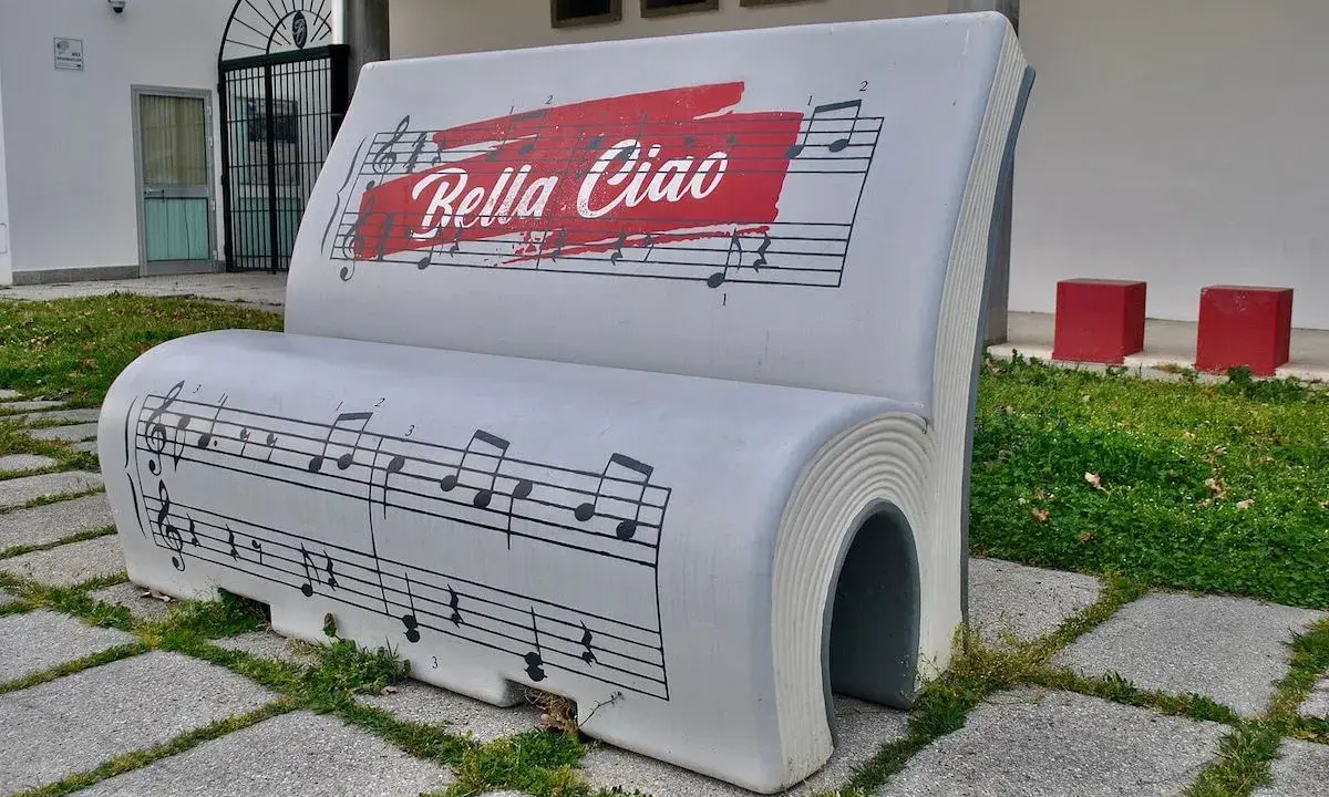 Ławka w kształcie książki z nutami i napisem "Bella Ciao". To symbol wolności i oporu, który znaczy "żegnaj piękna".