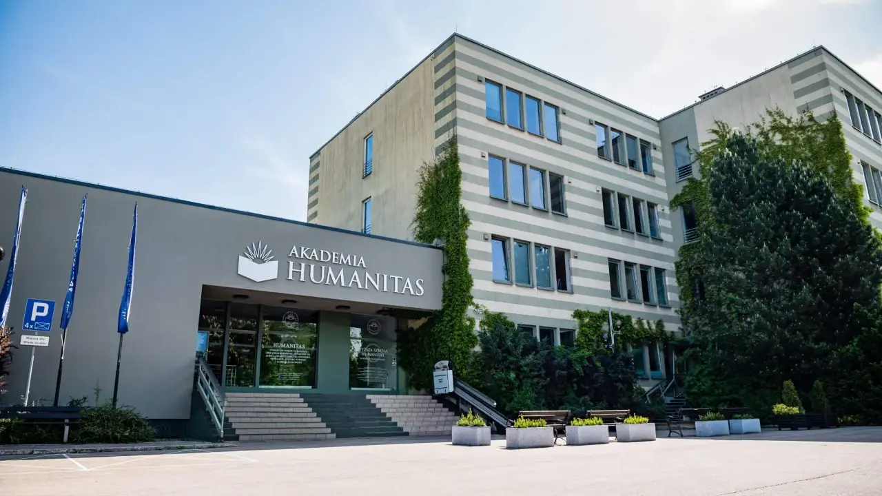 Akademia Humanitas w Katowicach, gdzie można studiować psychologię. Budynek z zielenią i parkingiem.