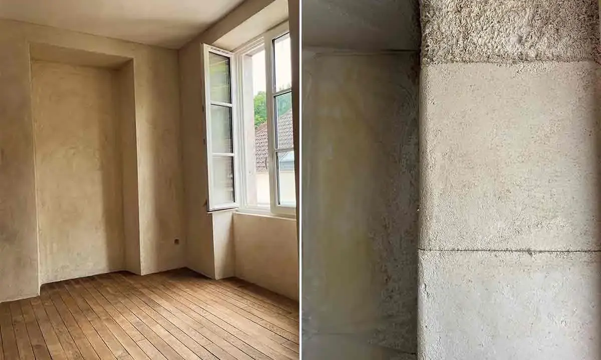 Intérieur d'une pièce aux murs enduits de chaux liège, avec un parquet en bois brut. Gros plan sur la texture rugueuse d'un mur en chaux liège.