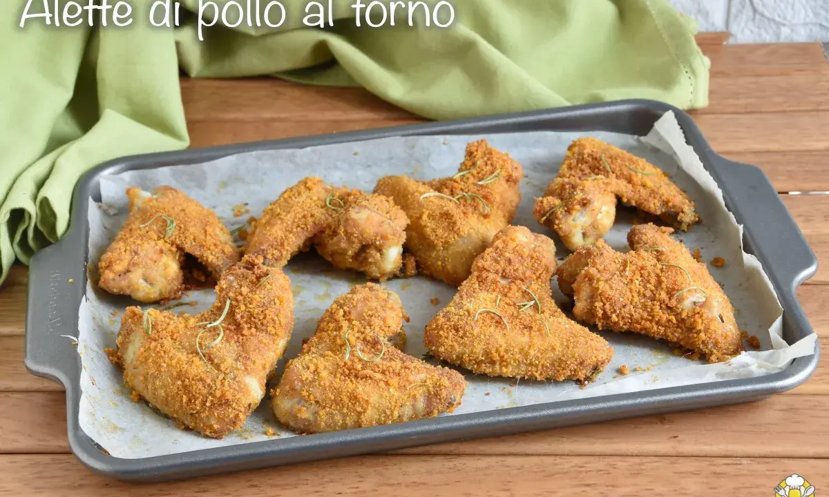 Alette di pollo al forno dorate e croccanti, guarnite con rosmarino fresco, pronte per essere gustate.
